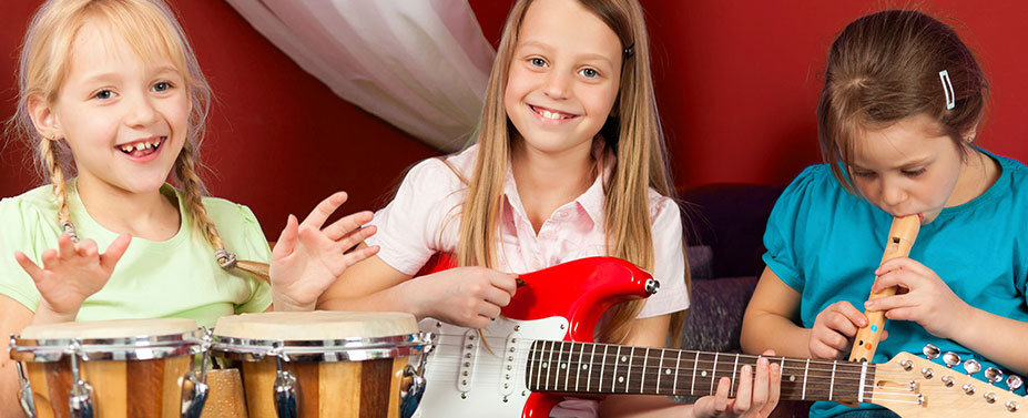 drei Mädchen musizieren mit Bongo, Gitarre und Blockflöte