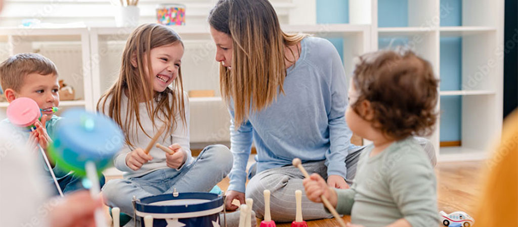 Das Bild der Musikschule Odenwald zeigt eine einfühlsame Musiklehrerin mit Kindern